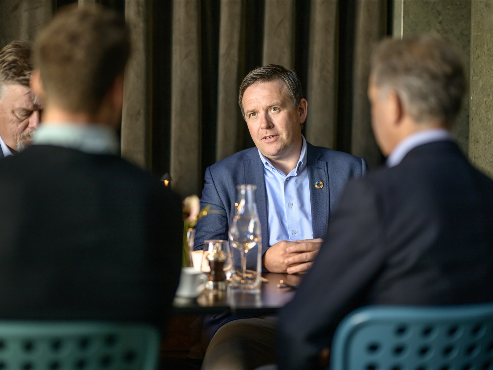 Visere colleagues in conversation around a table